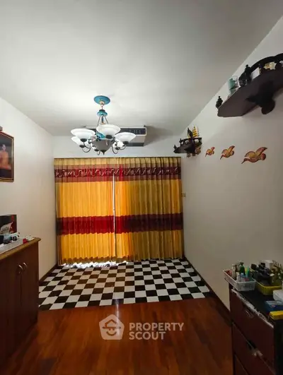 Charming living room with elegant chandelier and checkered floor, perfect for cozy gatherings.
