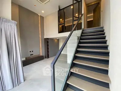 Modern duplex interior with sleek staircase and high ceilings, perfect for stylish urban living.