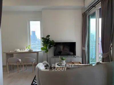 Modern living room with city view, stylish furniture, and natural light.