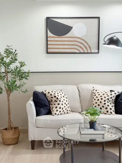 Stylish living room with modern decor, featuring a cozy sofa, chic artwork, and elegant lighting.