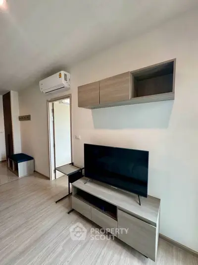 Modern living room with sleek TV stand and wall-mounted storage units.
