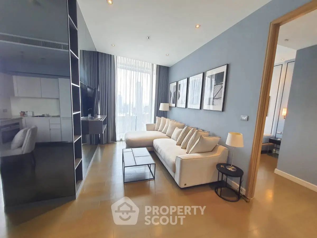 Spacious modern living room with elegant decor and large windows offering city views.