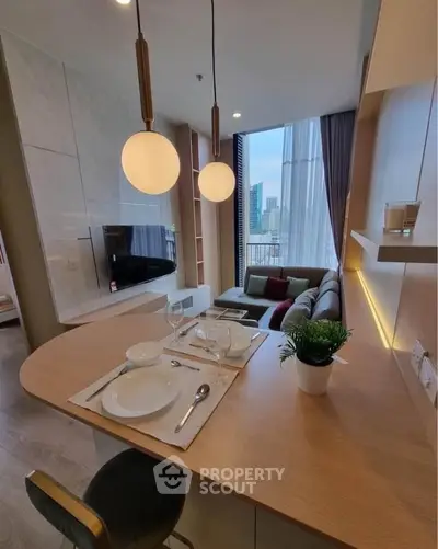 Modern open-layout living room with dining area and city view, featuring stylish lighting and cozy seating.