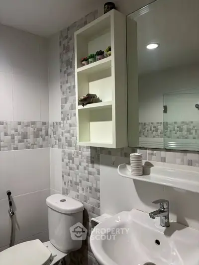 Modern bathroom with stylish tile design and functional storage shelves.