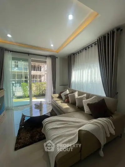 Modern living room with cozy sectional sofa and large windows for natural light.