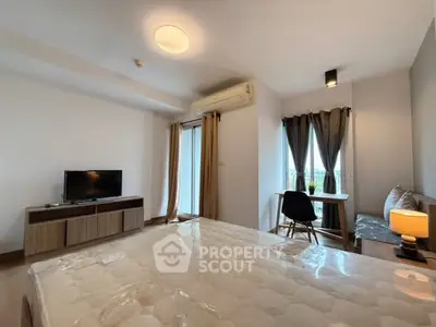 Modern bedroom with TV, air conditioning, and cozy dining area.