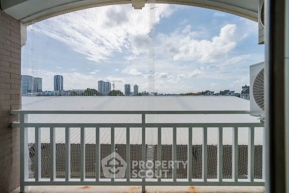 Stunning cityscape view from a balcony with protective netting, perfect for urban living.