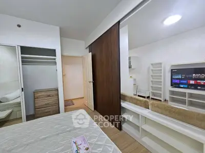 Modern bedroom with sliding closet doors and built-in shelves, featuring a cozy bed and stylish decor.
