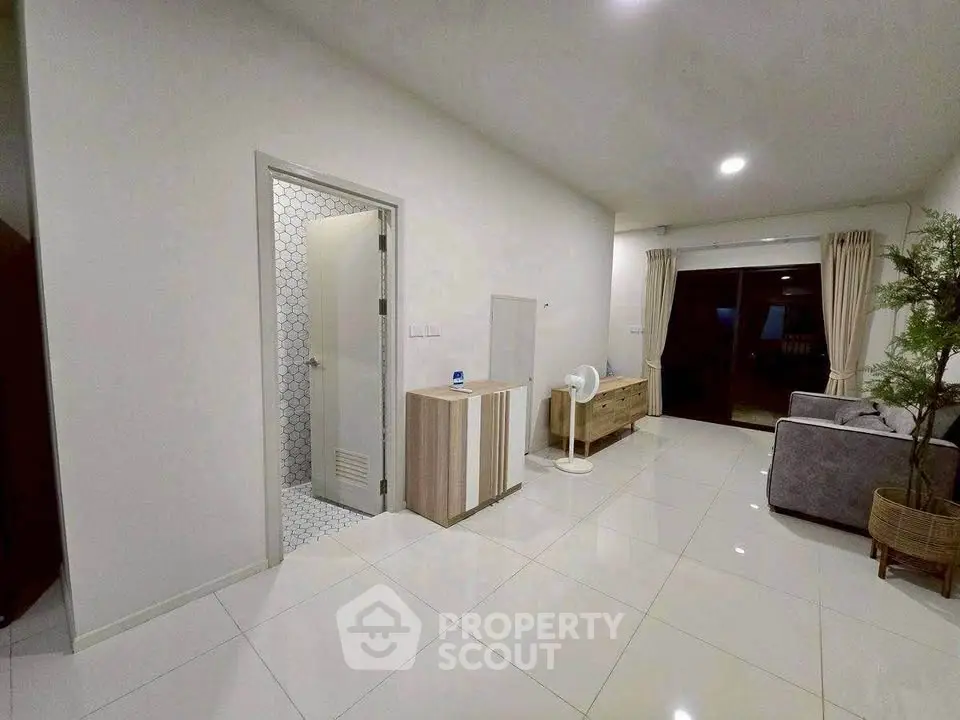 Spacious modern living room with sleek tile flooring and cozy furniture setup.