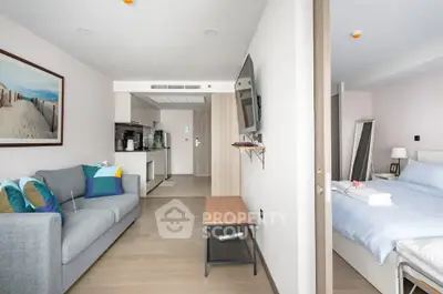 Modern open-plan living room and bedroom with stylish decor and natural light.