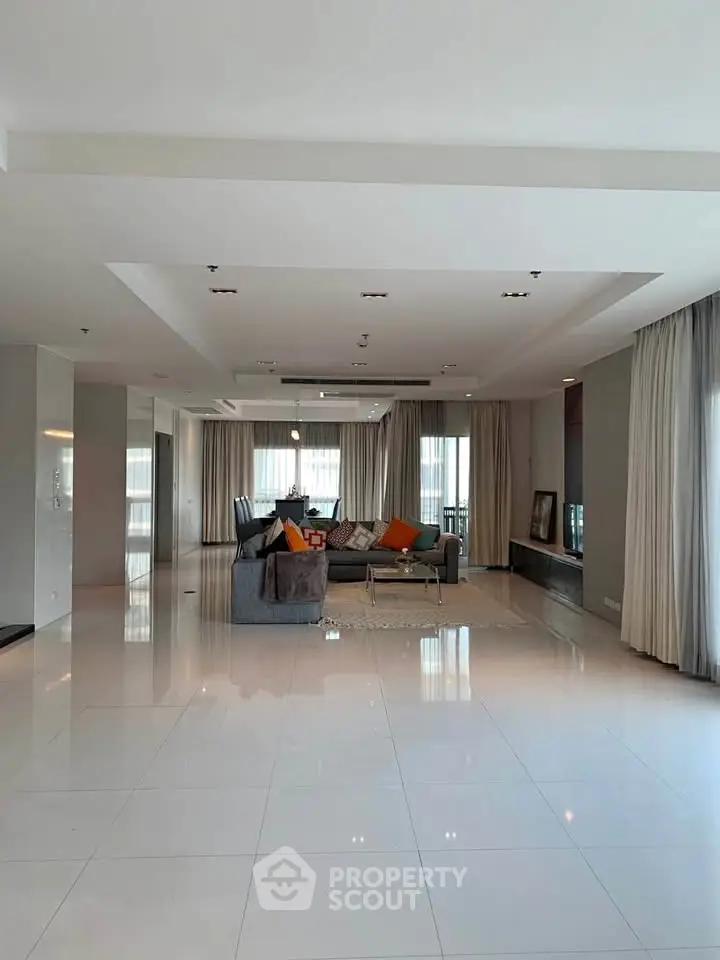 Spacious modern living room with sleek tile flooring and elegant decor