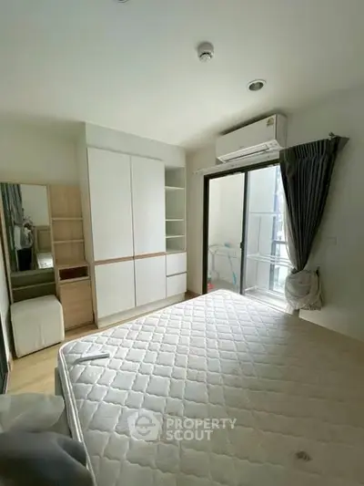 Bright and airy bedroom with balcony access and modern furnishings in a stylish apartment.