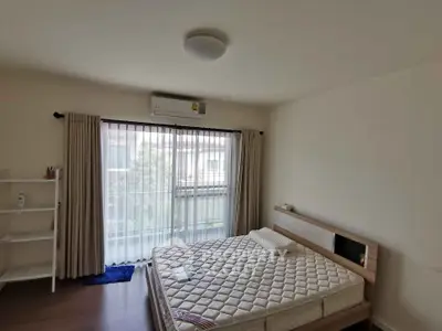 Spacious bedroom with natural light and modern furnishings in a cozy apartment.