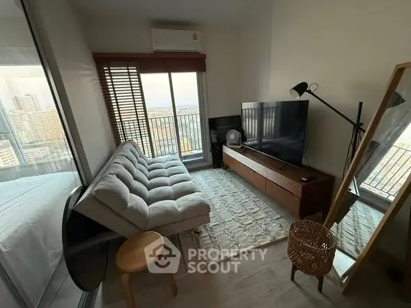 Modern living room with cozy sofa, large TV, and balcony view