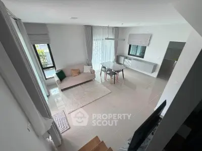 Spacious modern living room with elegant decor and large windows for natural light.