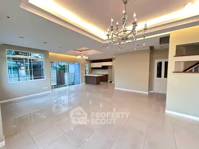 Spacious modern living room with elegant chandelier and open kitchen layout