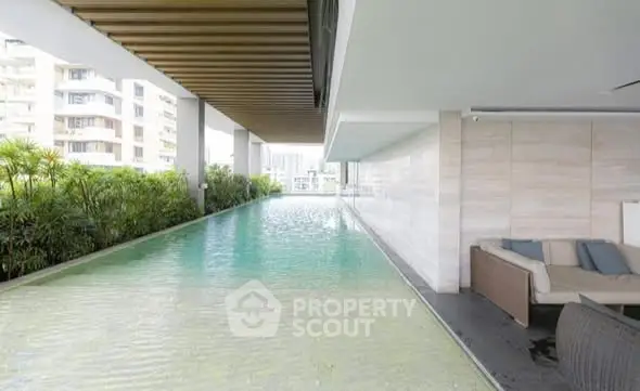 Luxurious modern pool area with sleek design and comfortable seating in a high-rise building.