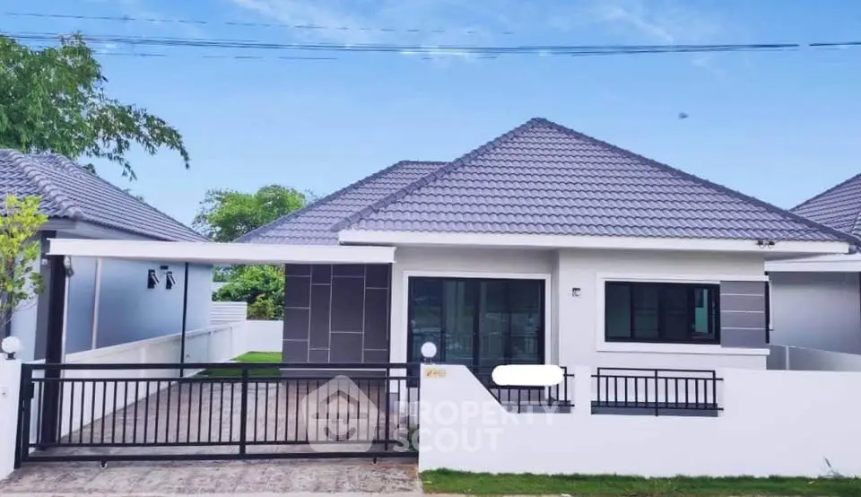 Modern single-story house with sleek design and spacious driveway in a serene neighborhood.