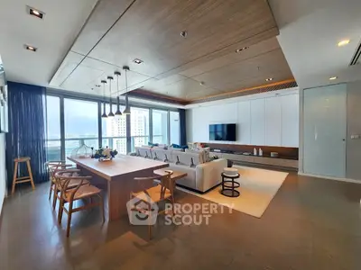 Luxurious open-plan living room with modern decor and stunning city view.