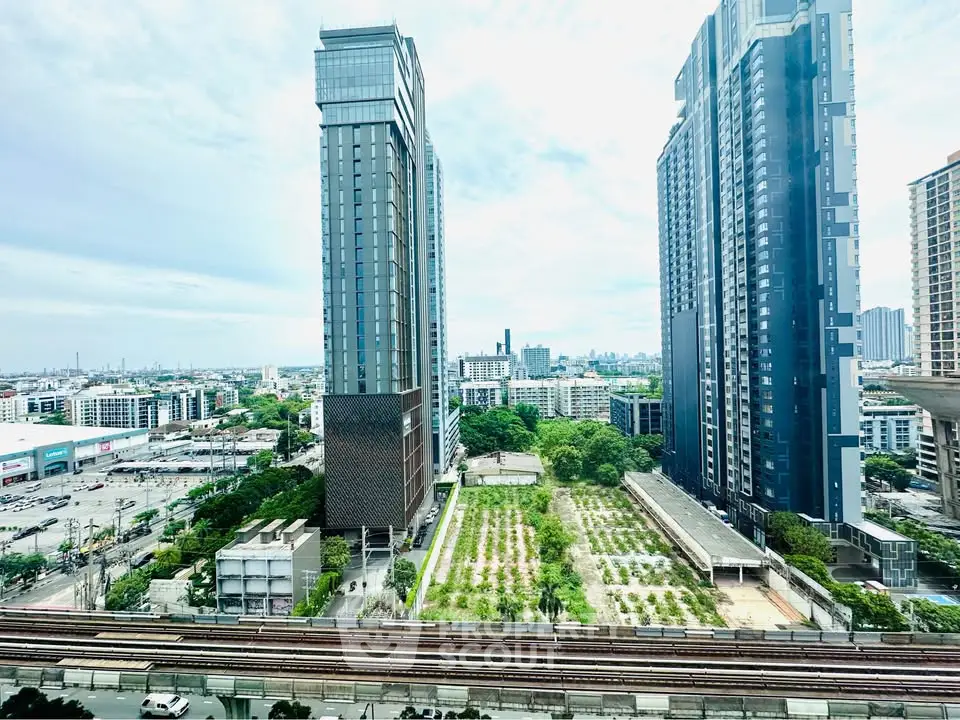 Stunning cityscape view from high-rise apartment with modern architecture and lush greenery.