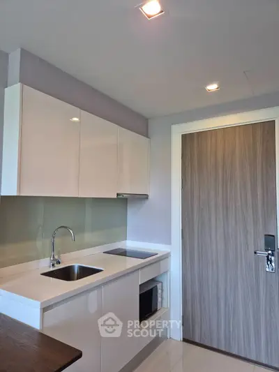 Modern kitchen with sleek cabinetry and built-in appliances in a compact layout.