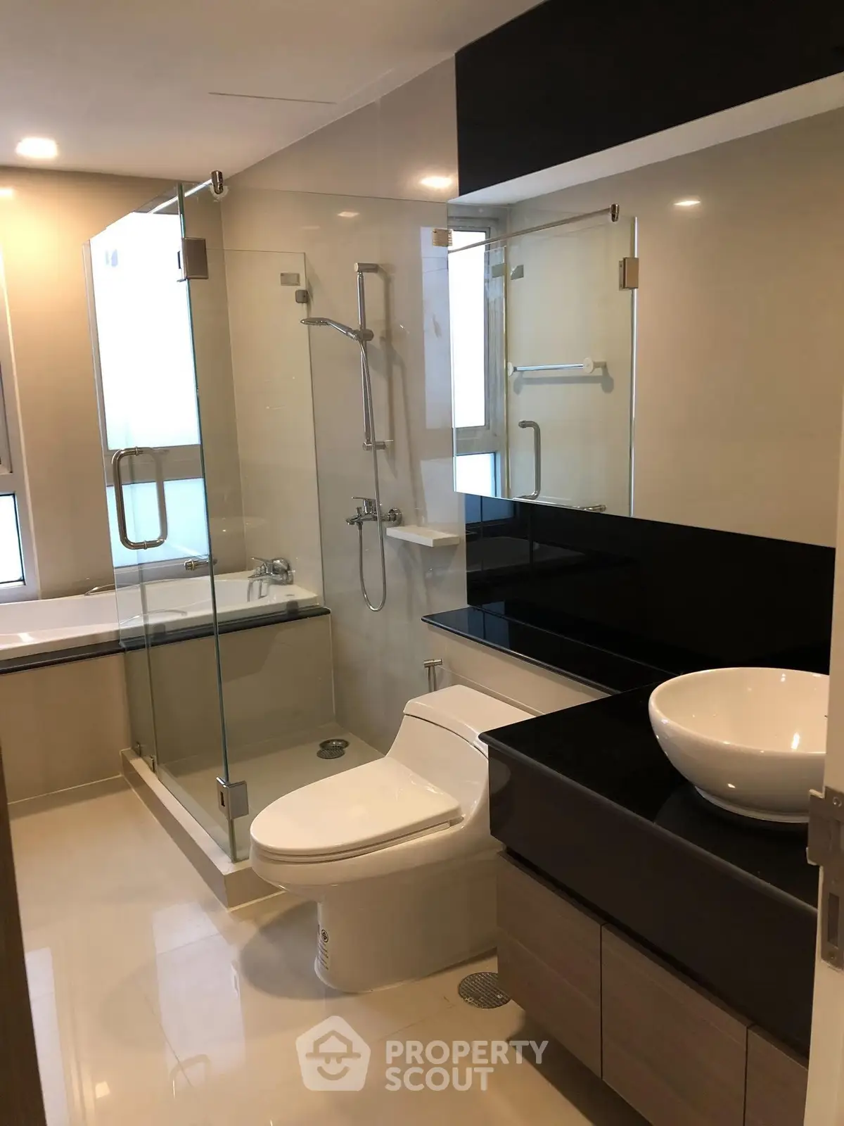 Modern bathroom with glass shower and sleek fixtures in a contemporary home.