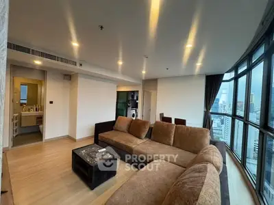 Spacious modern living room with panoramic city views and cozy seating area.