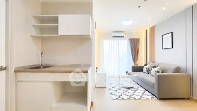 Modern open-layout living room with cozy sofa and stylish kitchen area, perfect for urban living.
