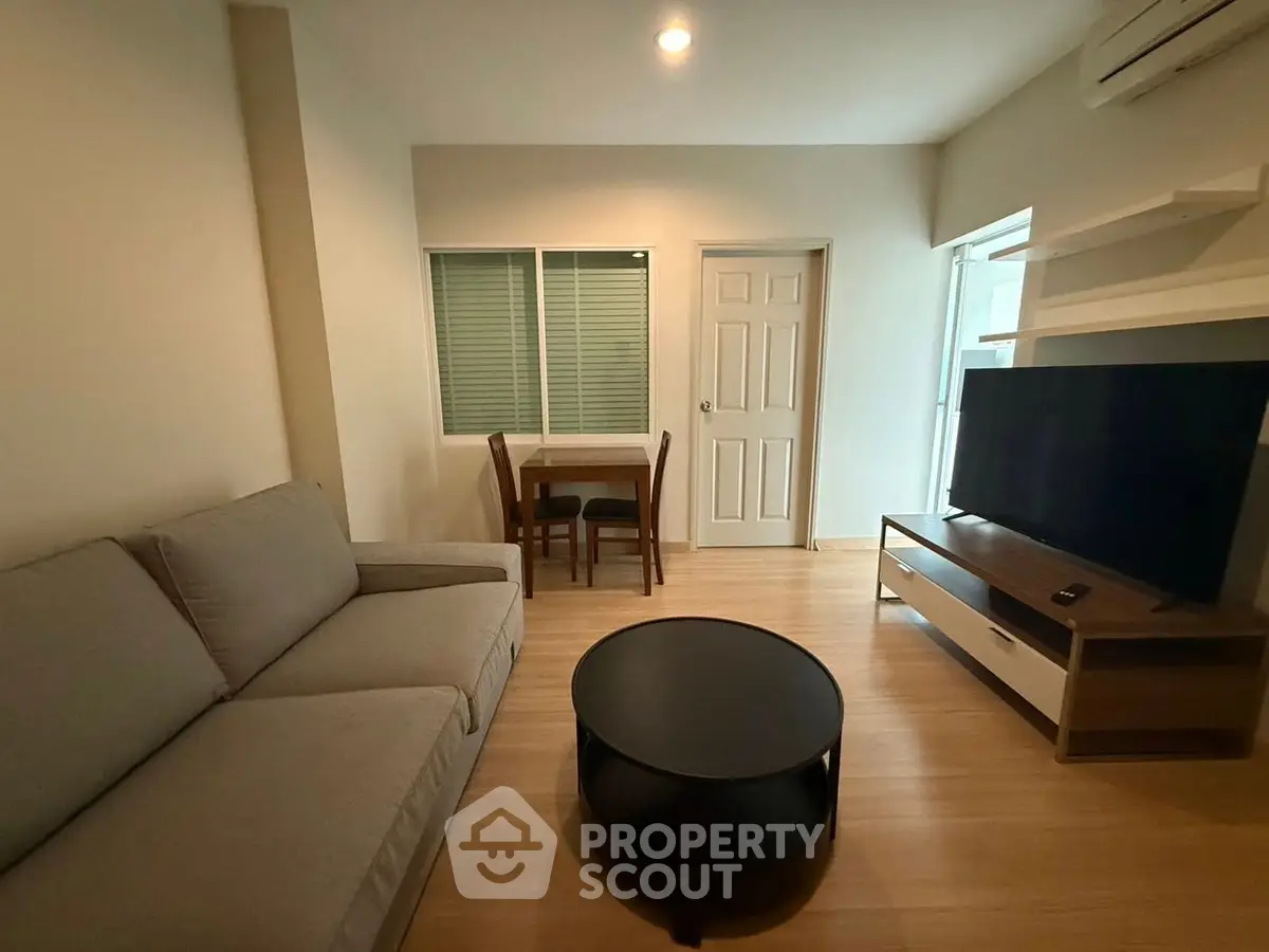 Cozy living room with modern furniture and large TV, perfect for relaxation.