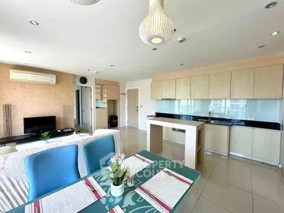 Spacious open-plan living room and kitchen with modern decor and ample natural light.