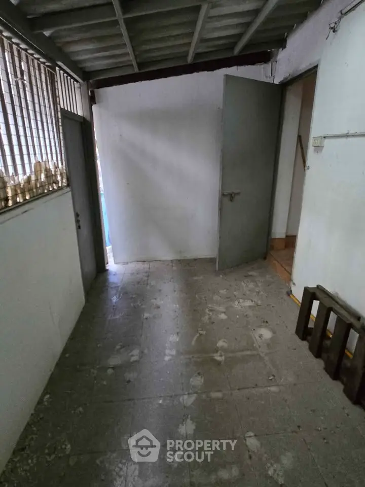 Unfinished storage room with concrete floor and metal door