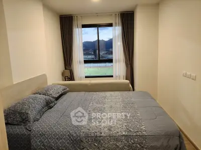 Cozy bedroom with a scenic view, featuring a comfortable bed and elegant curtains.