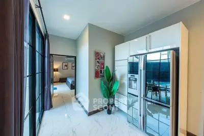 Modern apartment interior with sleek kitchen and spacious bedroom view