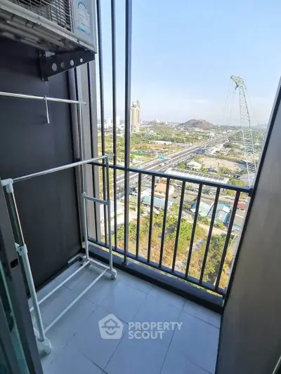 High-rise balcony with stunning city view and laundry rack, perfect for urban living.