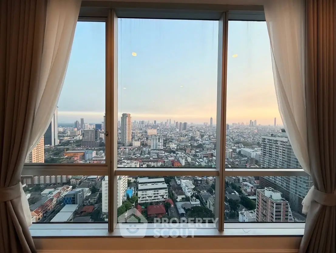 Stunning cityscape view from high-rise apartment window at sunset