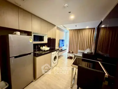 Modern open-layout kitchen and living area with sleek appliances and cozy seating.