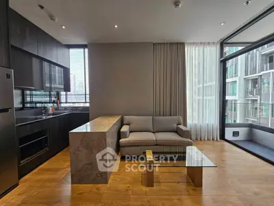Modern open-layout kitchen and living room with sleek design and large windows.