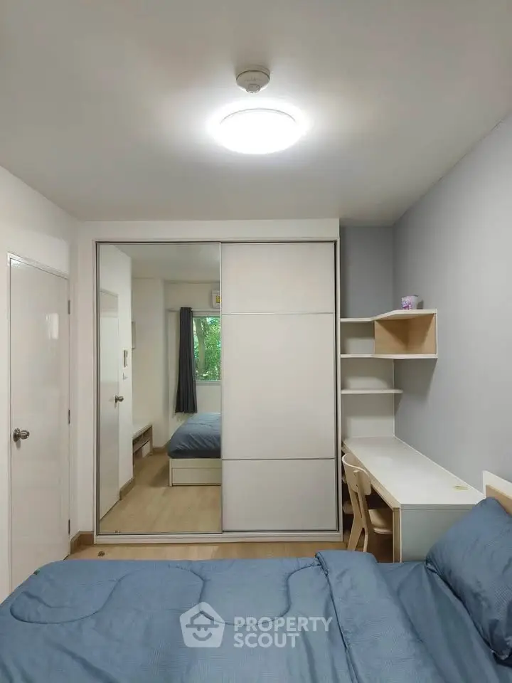 Modern bedroom with built-in wardrobe and study desk, featuring sleek design and ample natural light.
