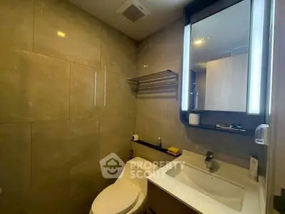 Modern bathroom with sleek fixtures and elegant tiling, featuring a stylish vanity and mirror.