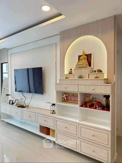 Modern living room with sleek TV setup and elegant built-in storage unit.