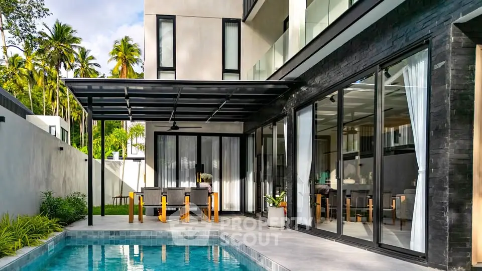 Luxurious modern home with poolside patio and sleek glass doors, perfect for entertaining.