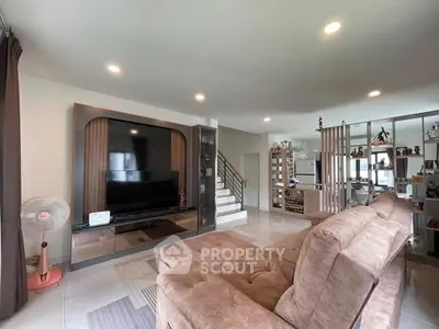 Spacious living room with modern decor and large TV, perfect for family gatherings.