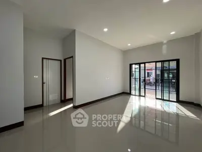 Spacious modern living room with large windows and glossy floors, perfect for natural light lovers.