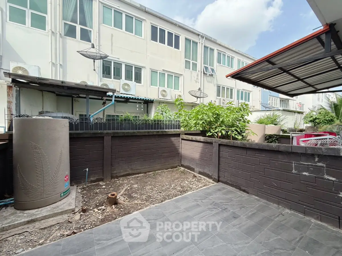 Spacious urban backyard with tiled patio and garden area, ideal for outdoor living.