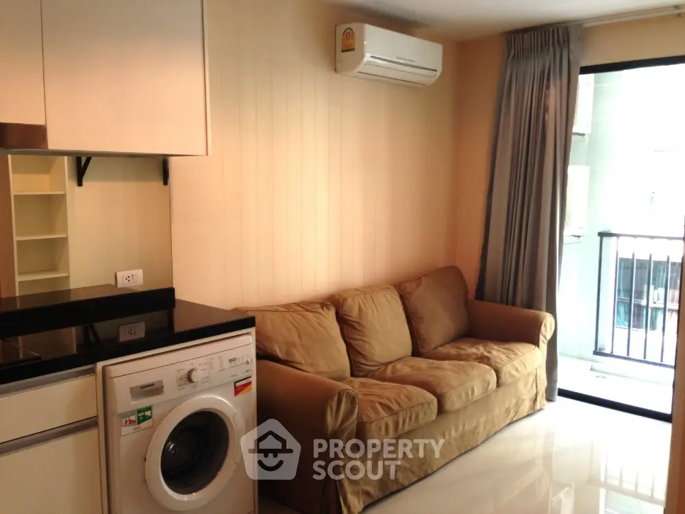 Modern living room with washing machine and balcony access