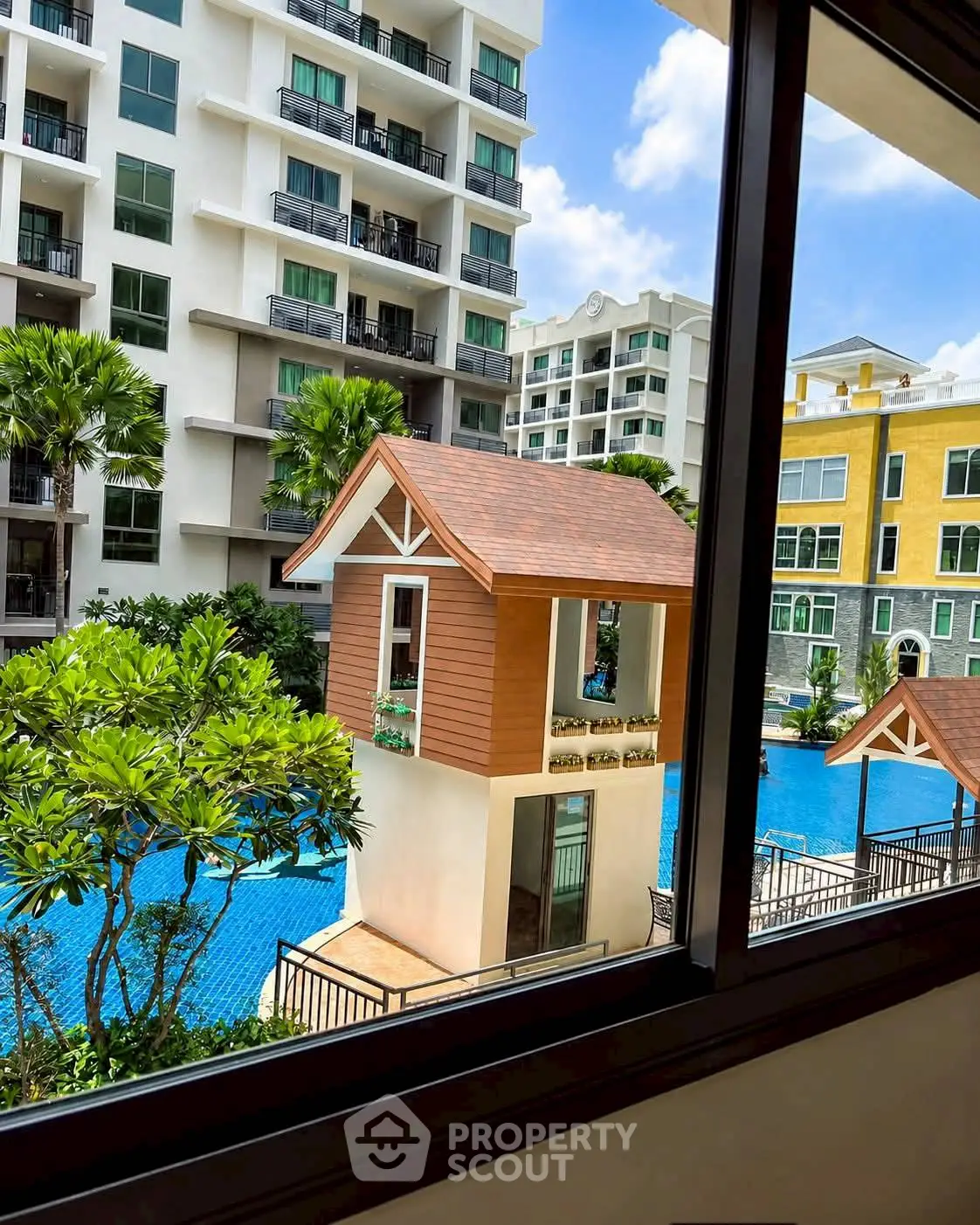 Luxurious condo with pool view and lush greenery, perfect for modern living.