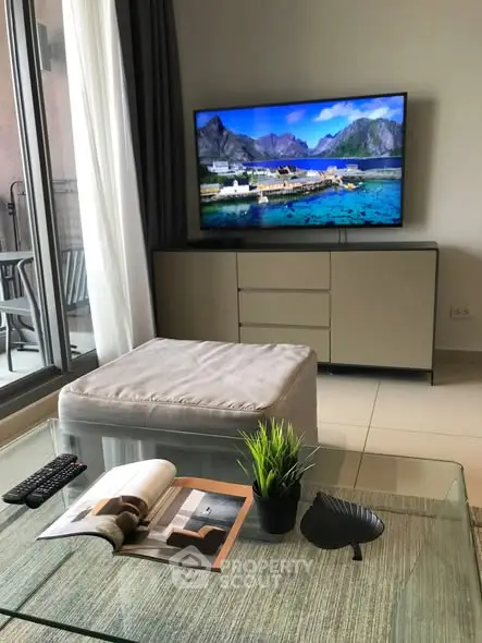 Modern living room with large TV and stylish decor, perfect for relaxation.