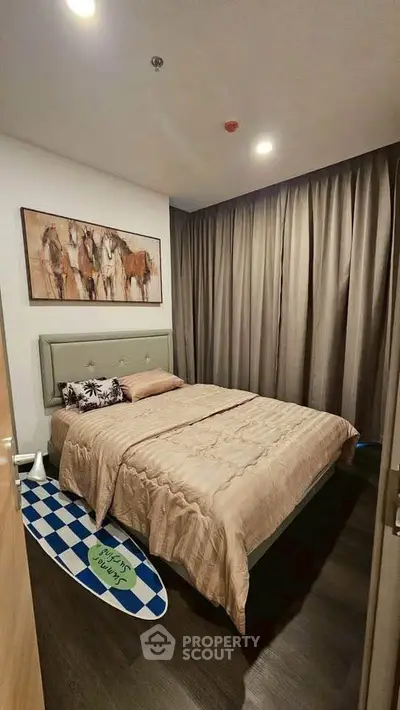 Cozy bedroom with elegant decor and warm lighting, featuring a stylish bed and artistic wall art.