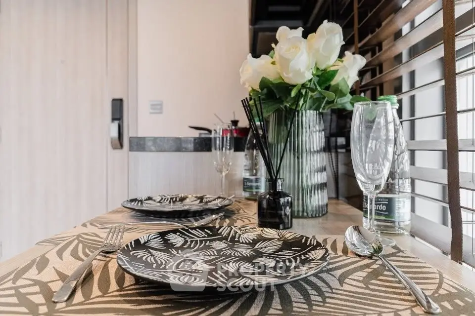 Stylish dining setup with elegant tableware and floral decor in modern kitchen.