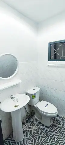 Modern bathroom with stylish tiles and round mirror